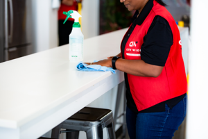 woman disinfecting table top